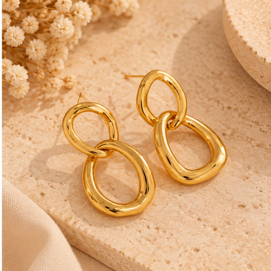Boucles Maëlys dorées posées sur fond beige