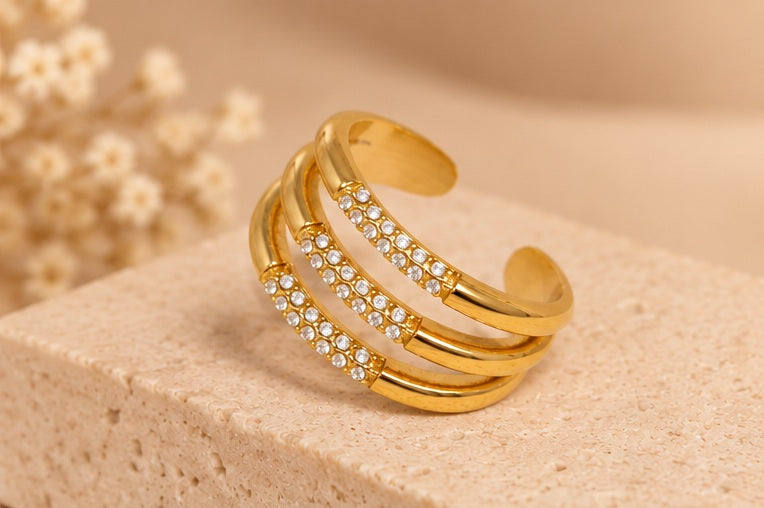 BAGUE CAMILLIA DORÉE posée sur fond beige